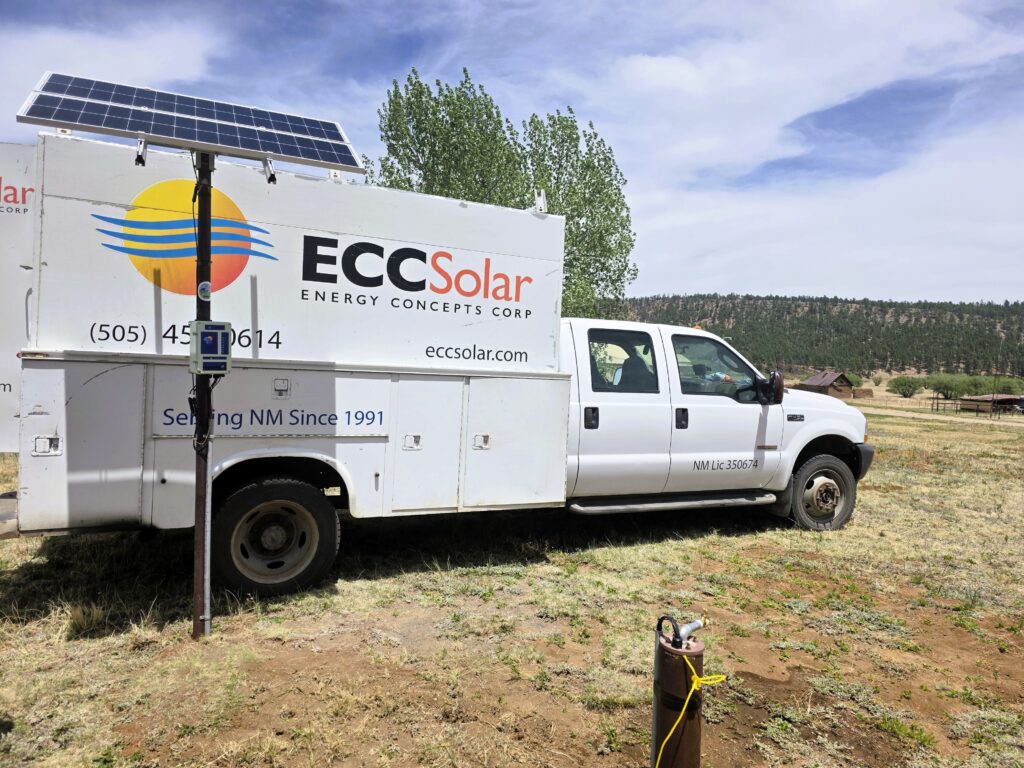 ECC Solar truck next to a ground-mounted solar panel